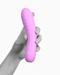 A hand holding a Creative Conceptions pink silicone pleasure toy against a monochrome background, emphasizing the item's color and texture.