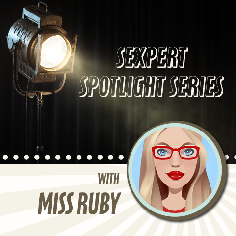 Black and beige graphic with a spotlight shining down on avatar of Miss Ruby who is caucasian with blonde hair, red glasses and lipstick and blue eyes. 