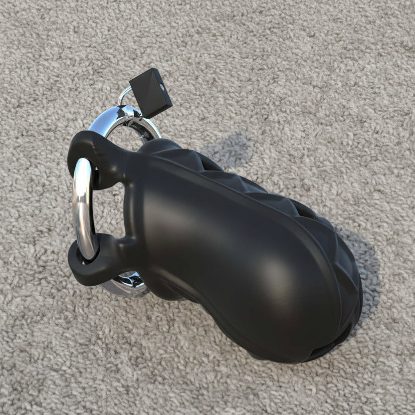 A black chastity device with a padlock is placed on a light gray carpeted surface.