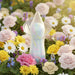 The Lily Dilly Squishy Waterproof Silicone Vibrator, with its iridescent petal-shaped design, stands upright among blooming roses, daisies, and other colorful flowers in soft sunlight.