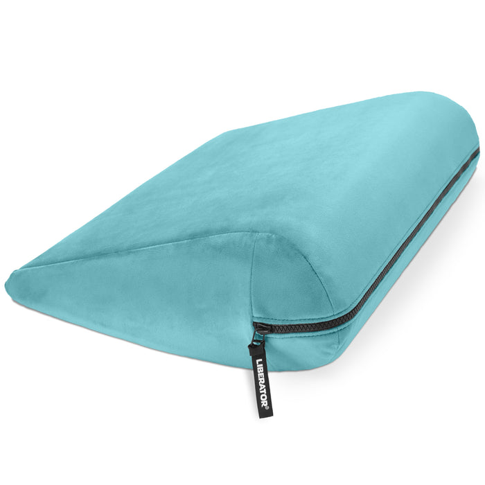 The Liberator Jaz – Discreet Positioning Support Cushion is a turquoise wedge pillow with soft fabric, visible zipper, and black "LUXELOFT" tag. Its ergonomic slope offers comfort and support, inspired by classic bedroom booster designs.