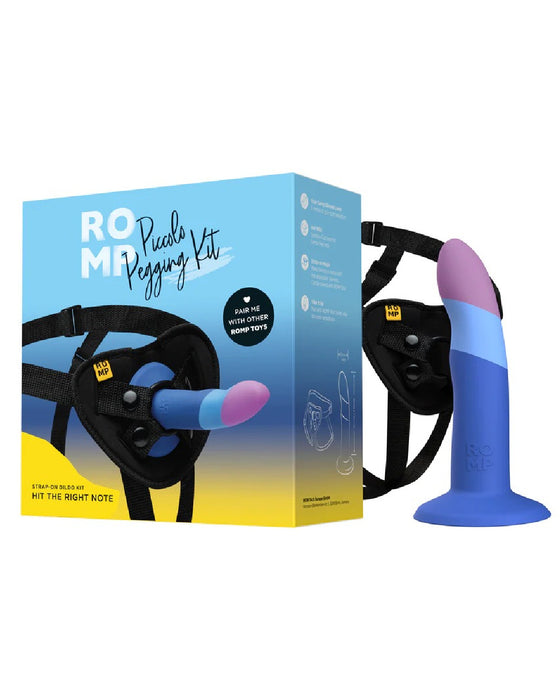 Product image of the Lovehoney Romp Piccolo First Time Pegging Kit, showing a blue and purple Piccolo dildo attached to a black harness, alongside the product packaging.