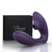 The Tracy's Dog OG Clitoral Sucking G-Spot Vibrator is a purple, curved silicone toy with a suction opening for dual stimulation, shown beside its black box.