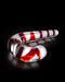 A glossy red and white striped borosilicate glass candy cane dildo lies against a dark reflective surface, creating a sleek and artistic holiday-themed presentation.