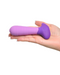 A hand holding a Pipedream Products Fantasy For Her Petite Vibrating Purple Butt Plug against a white background.