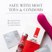 A bottle of JO Oral Delight Strawberry Arousal Gel 1 oz, its box, two wrapped condoms, and a pink vibrator are displayed. Text above states: "SAFE WITH MOST TOYS & CONDOMS" and lists latex and polyisoprene as compatible materials.