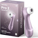 A Satisfyer Pro 2 Waterproof Pressure Wave Clitoral Stimulator in lilac is pictured beside its packaging, which features the product name and emphasizes its touch-free clitoral stimulation.