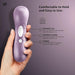A hand holds the Satisfyer Pro 2 Waterproof Pressure Wave Clitoral Stimulator in lilac, featuring three labeled buttons (+ for more intensity, - for less, and power). Text: "Comfortable to Hold and Easy to Use." Perfect for clitoral stimulation.