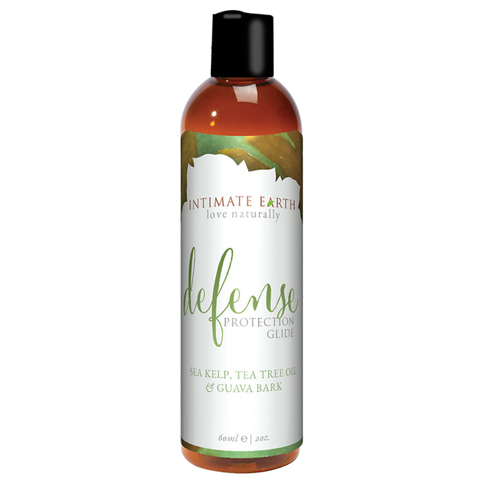 A 60ml (2oz) bottle of Intimate Earth Defense Anti-Bacterial Water Based Lubricant features a green and white label, black flip-top cap, and includes sea kelp, tea tree oil, guava bark, and carrageenan for added HPV protection.