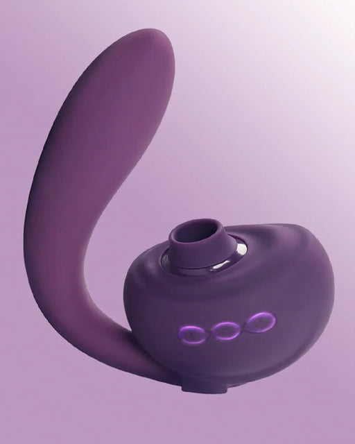A waterproof purple silicone Tracy's Dog OG 3 Clitoral Suction & G-Spot 2 in 1 Vibrator with a curved design on a pink background.