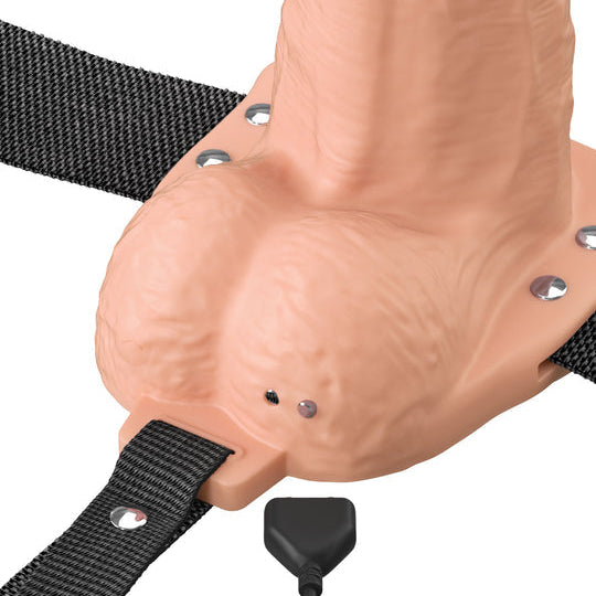 A close-up of the Fantasy X-Tensions Elite Vibrating Hollow 6 Inch Silicone Dildo & Strap-On Harness – Vanilla, featuring realistic flesh-toned silicone, black adjustable straps with metal studs, and a small cable at the base for vibration.