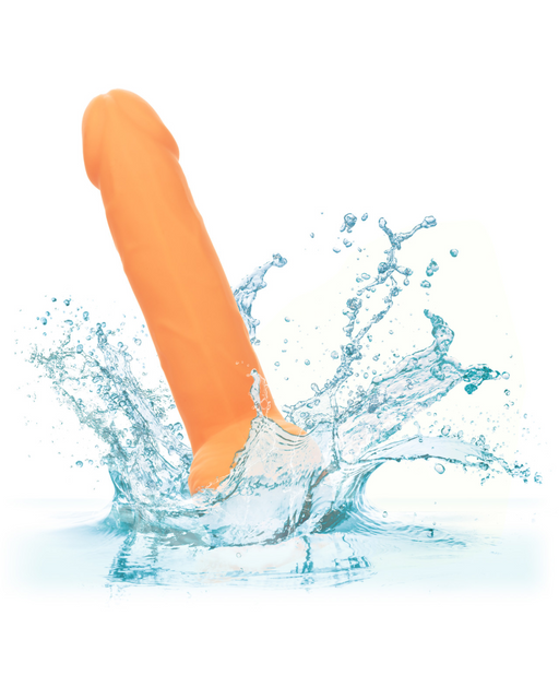An **orange**, cylindrical object with a contoured silicone material splashes into clear blue water, creating dynamic water splashes and droplets around it. The plain white background emphasizes the action and motion of the splash. This scene features the **CalExotics Silicone Stud 8 Inch Suction Cup Dildo - Orange**.