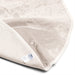 A close-up of the Dame Thro Soft Waterproof Sex Blanket, showing its light color, ultra-soft cotton top with a wet stain, flipped corner revealing the waterproof underside and fabric tag. The blanket is machine washable for easy care.