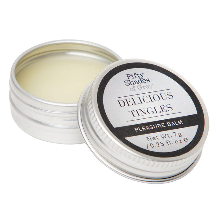 A small open tin from the Fifty Shades of Grey Desire Blooms Kit reveals creamy balm for clitoral stimulation, with its labeled lid resting beside it.