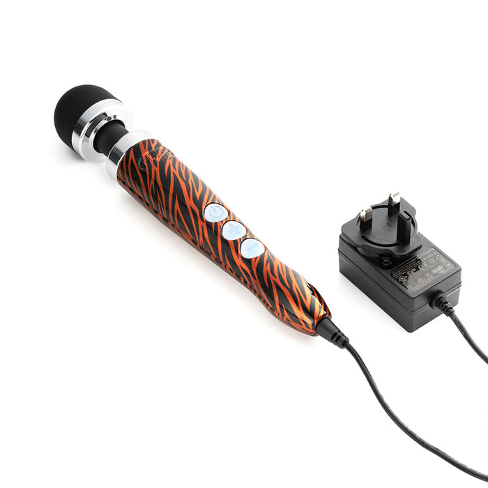 The Doxy Die Cast 3 Compact Wand Vibrator Tiger Stripe features a black and orange tiger stripe design, three silver buttons, delivers targeted vibrations, and includes a black power adapter.