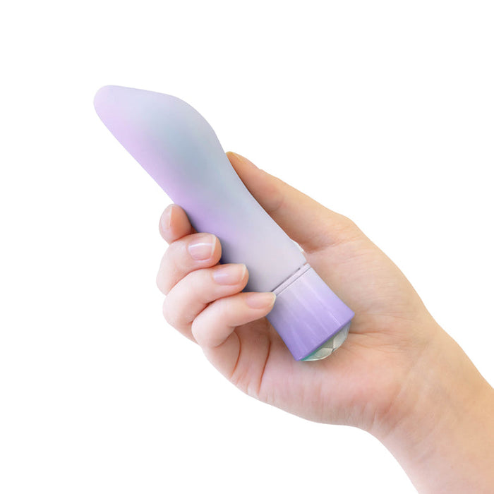 A hand holding the Opal Heating Waterproof Silicone Vibrator, crafted from silky silicone in a vibrant purple hue.
