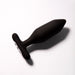 The Je Joue Onyx Large Powerful Remote Control Vibrating Butt Plug features a black silicone, tapered shape with a flared base, shown on a white surface with shadow, and delivers deep rumbly vibrations for enhanced pleasure.