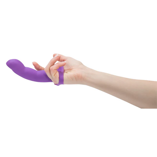 A hand wears the Simple and True Silicone G-Spot Finger Extender in purple on two fingers, with the device extending outward. Designed for targeted g-spot stimulation. The plain white background highlights the product.