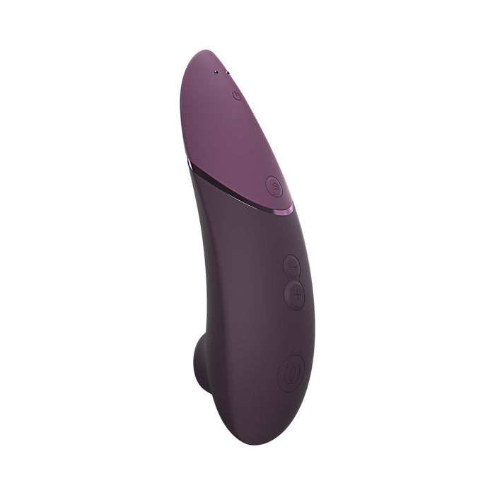 The Womanizer Next Pleasure Air Clitoral Vibrator by Womanizer features a plum-colored, ergonomic design with a curved, smooth surface. Integrating innovative Pleasure Air Technology, it includes multiple control buttons for power and intensity settings along its side. The sleek toy culminates in a slightly pointed tip to enhance your experience.