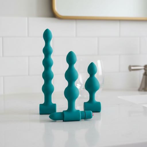 The Bumpy 3-Piece Beaded Anal Plug Set with Vibrating Bullet includes three teal beaded plugs of various sizes and shapes, each displayed upright, with one plug featuring a removable vibrating bullet for customizable pleasure.