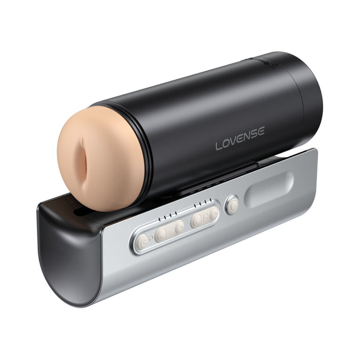 The Lovense Solace Pro AI Powered Thrusting Masturbator with Remote Control, in black and beige, sits on a silver dock with multiple buttons for hands-free pleasure and advanced interactive features.
