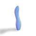 The Dame Dip Beginner's Internal & External Silicone Vibrator in Periwinkle stands upright on a white background with a soft shadow to the left, offering gentle, versatile, and waterproof pleasure in an elegant curved design ideal for beginners.