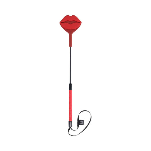 The Kiss Crop with Red Silicone Lips is a riding toy with a red handle, flat lip-shaped silicone tip, black wrist strap, and is shown on a white background.