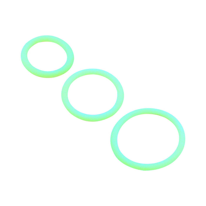 Three glow-in-the-dark rings from the Family Jewels Penis Ring Variety Pack, each in a different size, are arranged diagonally on a white background.