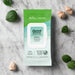 A 30-count pack of Good Clean Love Balance Personal Moisturizing & Cleansing Wipes is shown on marble with green leaves and dried beige flowers. The pH balanced packaging features aloe, freshness, and a "Do Not Flush" label.