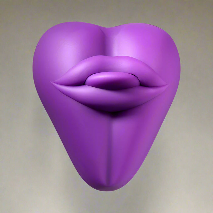 The Bananapants Kissi Dildo Base features sculpted lips and a tongue on a heart-shaped, purple body made from body-safe silicone, shown against a white background with a sleek, modern design.