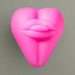 The Bananapants Kissi Dildo Base with Lips and Tongue is a bright pink, heart-shaped silicone accessory featuring stylized lips and smooth, rounded contours, shown on a plain white background.
