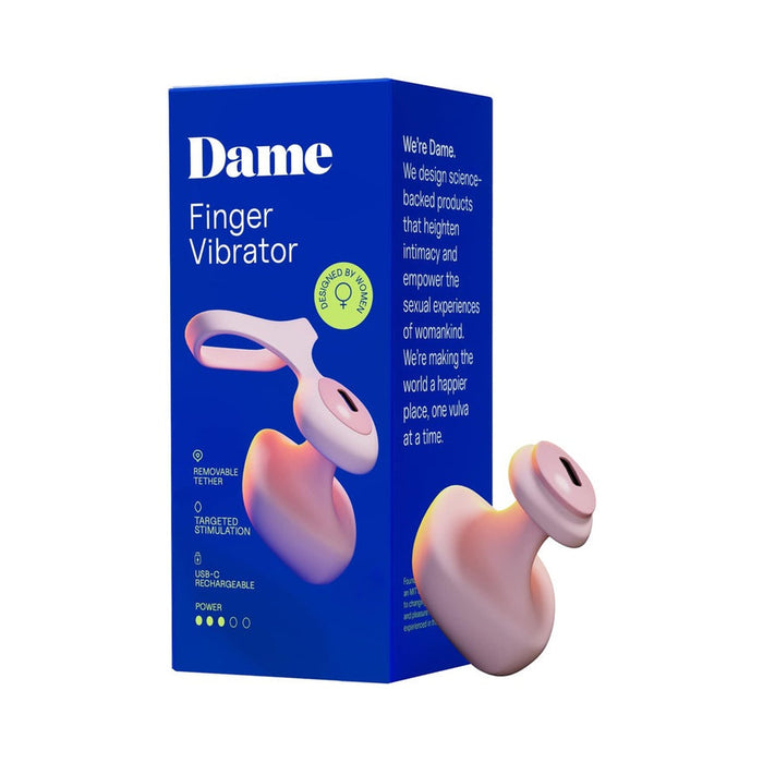 Pink silicone Dame Fin finger vibrator with a removable tether shown next to its blue product packaging box.