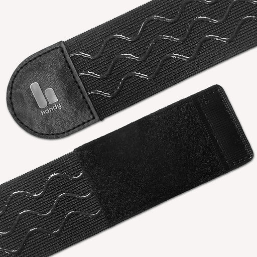 Close-up of The Handy TrueGrip Pro Band, a black elastic sleeve holder with wavy anti-slip silicone grip lines, Velcro ends, and a small “handy” logo on a leather-like patch.