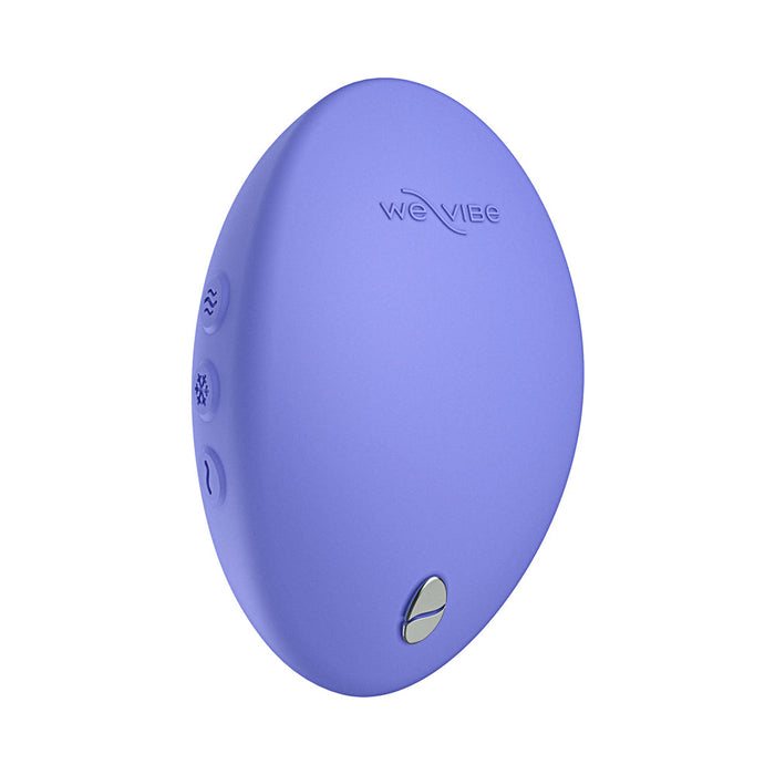 The We-Vibe Temp Lay On Vibrator is a purple, oval-shaped personal massager with hot and cold functions, featuring three small buttons and a metallic accent.