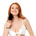A smiling woman with long red hair, in a white bikini top, holds the Sex & Mischief Black Wrist Feather Tickler near her chin, adding a playful touch against a plain white background.