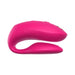 The We-Vibe Chorus Pro Wearable Couples' Vibrator features a bright pink, curved silicone design with triple motors and remote control—shaped for comfort, textured grip, and perfect for couples’ play and targeted G-spot stimulation.