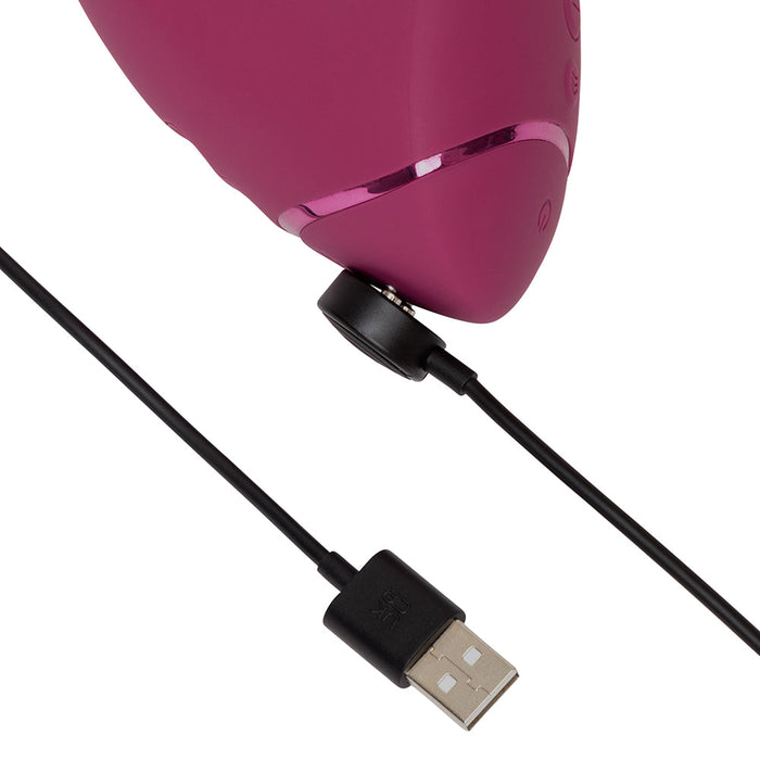 A close-up of the Womanizer Next Duo Pleasure Air + Vibration Blended Orgasm Stimulator being magnetically charged with a black USB cable, ready to deliver effortless blended pleasure.