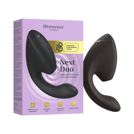 The Womanizer Next Duo Pleasure Air + Vibration Blended Orgasm Stimulator in black is shown next to its purple and yellow box. It features a curved design, side buttons, and combines 3D Pleasure Air technology with vibration for blended orgasms.