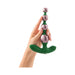 A hand holds the Bougie Vibrating Aluminum Anal Beads, a green and metallic pink beaded anal toy with a flared base, against a white background.