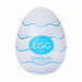 A white, egg-shaped male masturbator with wavy blue lines, featuring a textured sleeve for heightened pleasure. Sold as the "Tenga Egg Standard 3 Pack Disposable Masturbators I," with branding on the front.