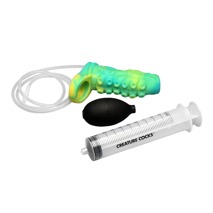 The Siphon Green Tentacle Squirting Penis Enhancer—green and yellow with a loop and tube—comes with a black bulb pump and a clear plastic “CREATURE COCKS” syringe, all displayed on a white background.