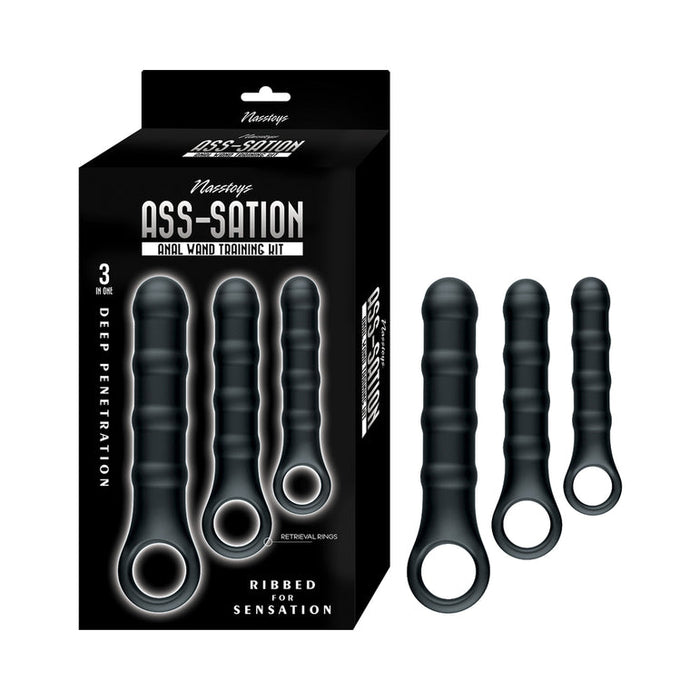 Three black, ribbed anal plugs with looped handles are displayed next to their packaging labeled "Ass-Sation Silicone Anal Wand Training Kit," making it an ideal beginner-friendly anal training kit for deep penetration and enhanced sensation.
