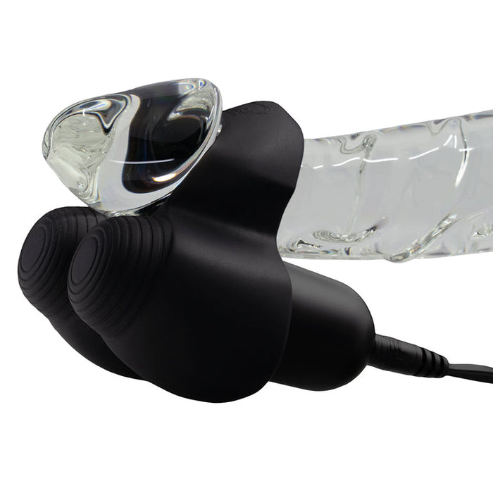A close-up of a transparent, curved glass object attached to the Hot Octopuss Jett Turbo Hands-Free Masturbator, featuring ridged circular ends and a plugged-in power cord.