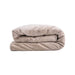 The Splash Blanket The OG Waterproof Blanket - Medium in light beige, neatly folded to showcase its soft, velvety texture, is displayed against a plain white background.