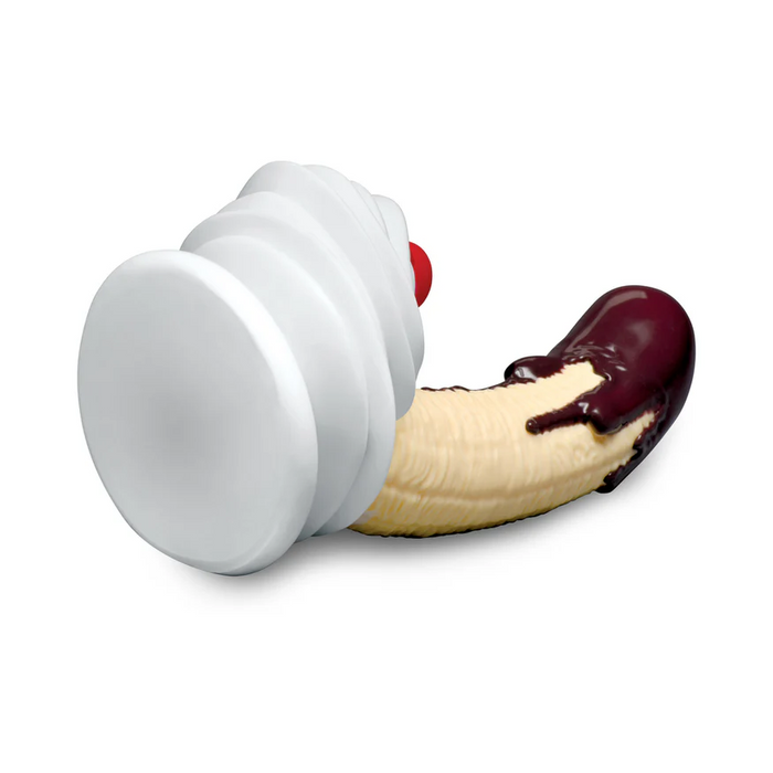 The Chocolate Dipped Banana Split Silicone Dildo with Suction Cup is shaped like a banana partially dipped in chocolate, featuring a white suction base with a red button, and shown on a plain white background.