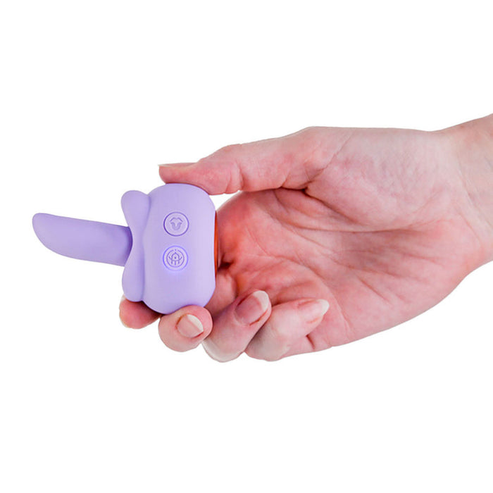 Hand holding a compact, lavender silicone M'Lady rotating tongue stimulator with two control buttons.