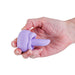 Compact lavender silicone rotating tongue stimulator held in a hand, featuring a soft-touch ergonomic design.