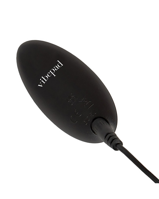 An oval-shaped black VibePad 3 Ride On Hands-Free Humping Vibrator with G-Spot Probe with a cable on a white background.