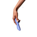 A hand with light brown skin and manicured nails holds the Dame Dip Beginner's Internal & External Silicone Vibrator in Periwinkle against a plain white background.