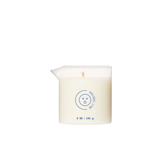 The Melt Together Massage Oil Candle by Dame (Green Tea, Fig & Cedarwood) is a white, plant-based 5 oz / 141 g candle in a clear glass container with a spout, blue text, and circular design on the front, placed against a plain white background.